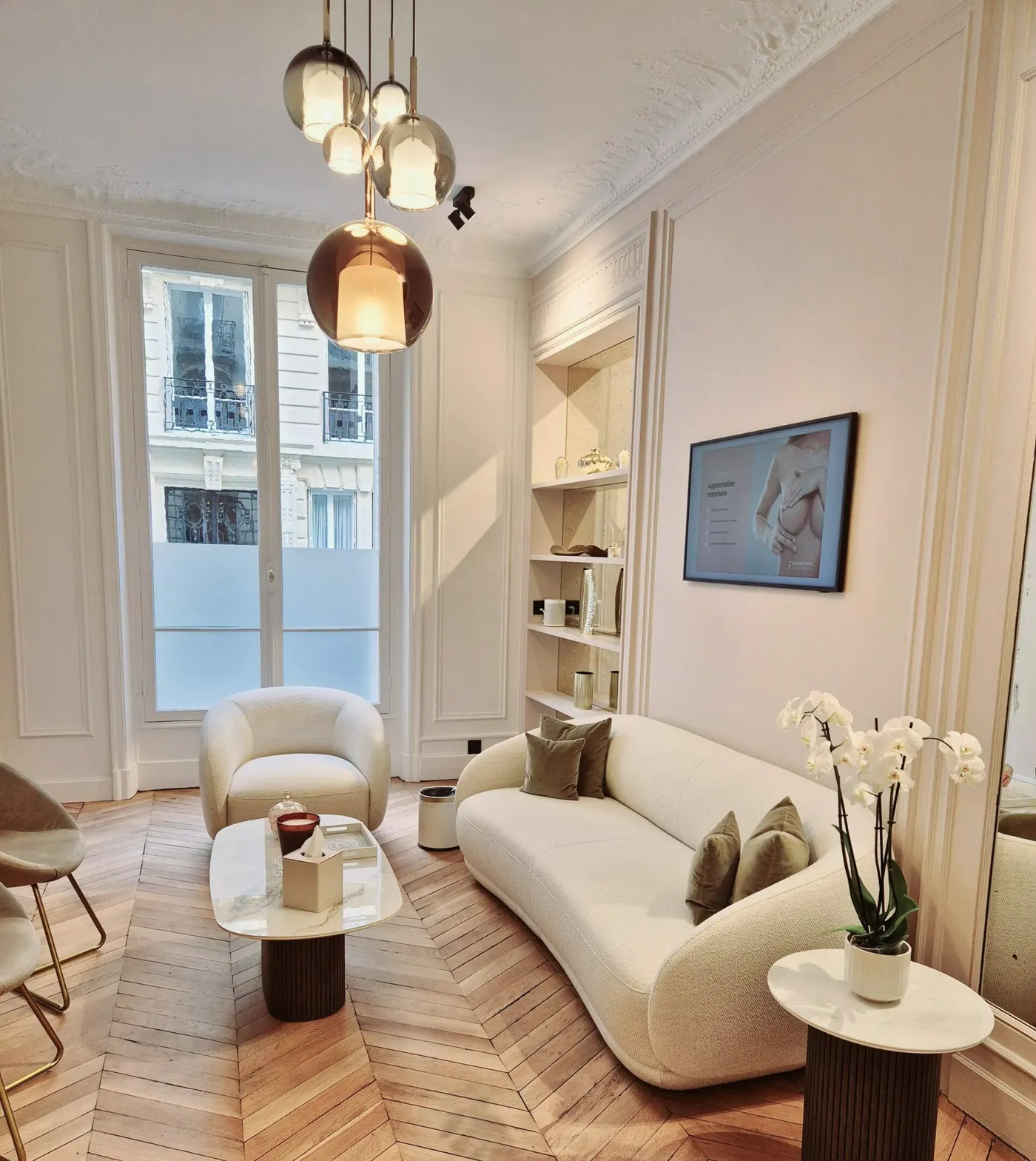 Salon d'attente du cabinet : moulures, parquet en point de Hongrie, canapé et fauteuil clairs